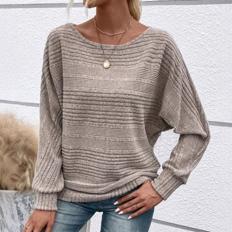 Jersey rayado gris topo de punto, manga larga abullonada y cuello redondo.