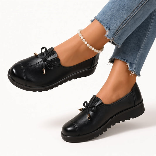 Mocasines flexibles negros con lazo frontal y suela gruesa