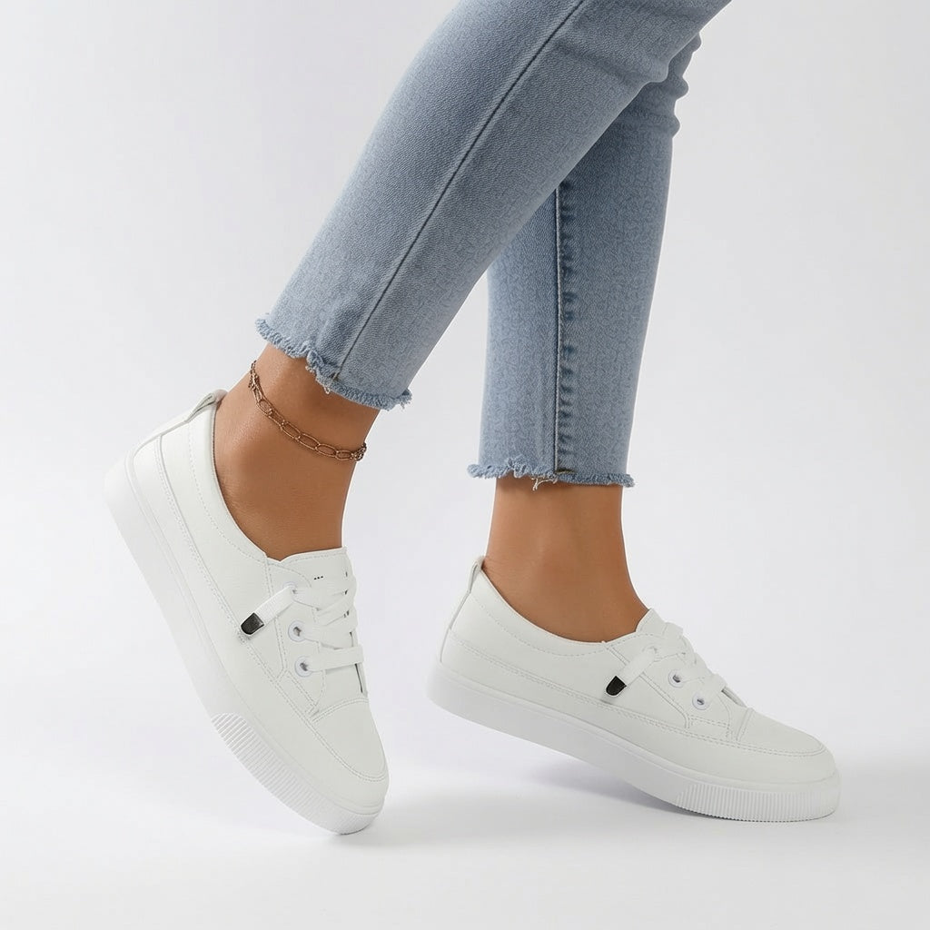 Zapatillas deportivas blancas con ojales negros y cordones, suela acanalada