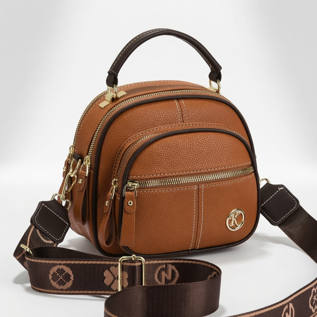 Bolso bandolera compacto de cuero marrón con cierre, correa ajustable y placa circular K.