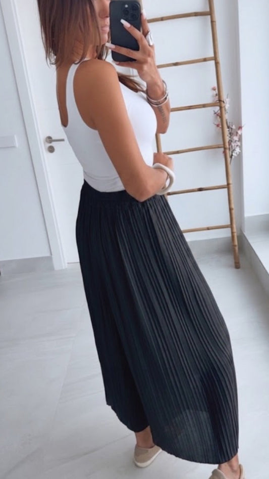 Pantalones plisados negros con pierna ancha y pliegues verticales, vista lateral