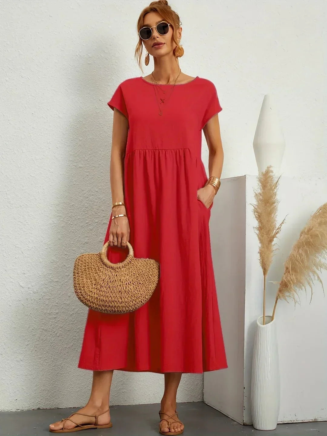 Vestido midi fluido rojo con escote redondo y falda con vuelo fruncida.
