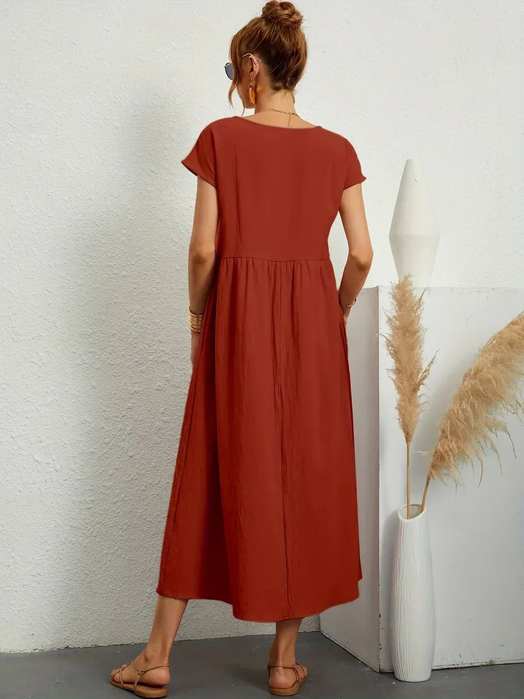 Vestido midi fluido rojo teja con fruncido en la cintura y falda con vuelo.