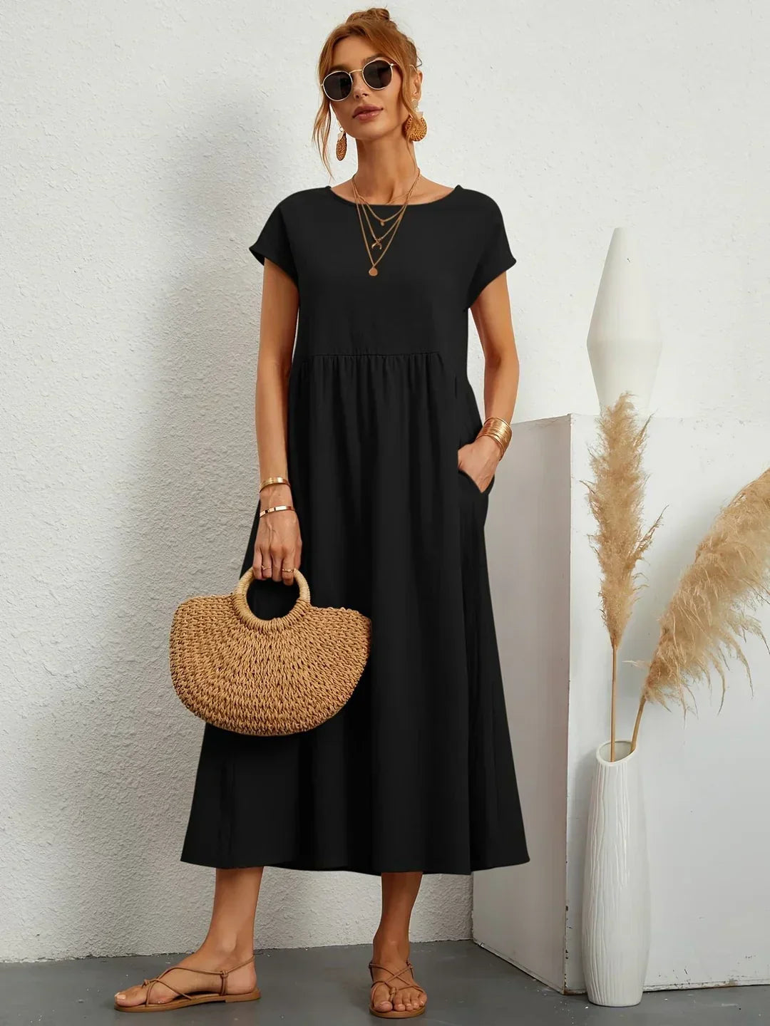 Vestido midi fluido negro, cuello redondo, manga corta y falda con frunces