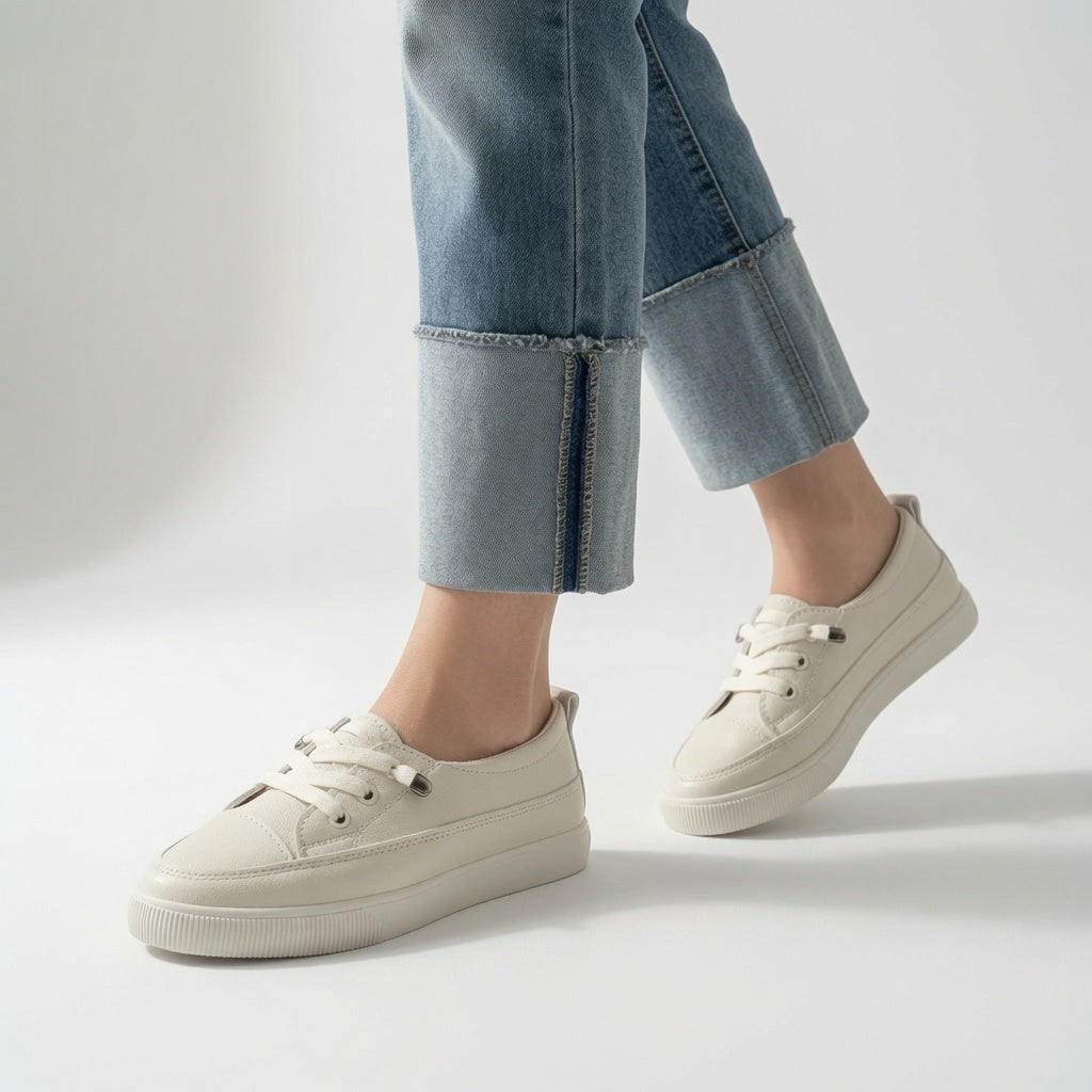 Zapatillas deportivas beige claras con cordones, costuras visibles y suela blanca