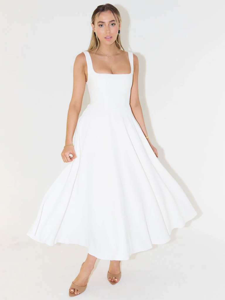 Vestido fluido blanco de tirantes finos, falda amplia y vuelo