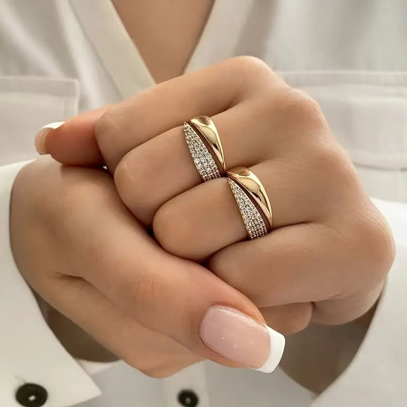 Dos anillos de oro con banda de piedras brillantes, sobre la mano