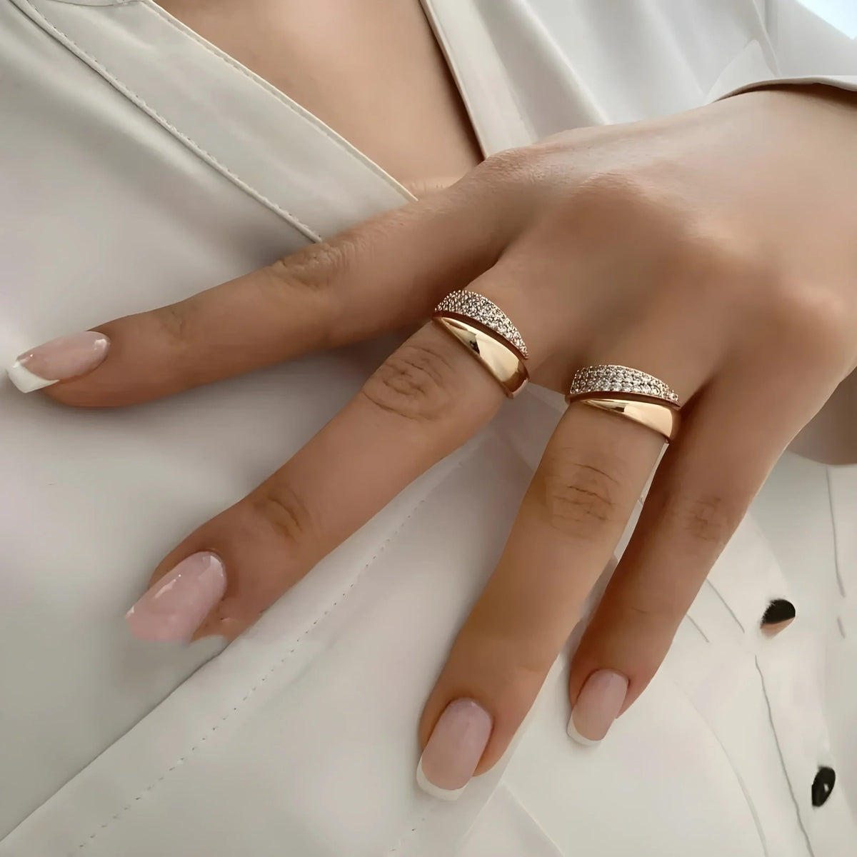 Par de anillos de oro con piedras brillantes tipo banda, en la mano