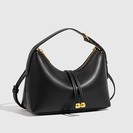 Bolso hobo de piel lisa negro con asa superior y herrajes dorados.