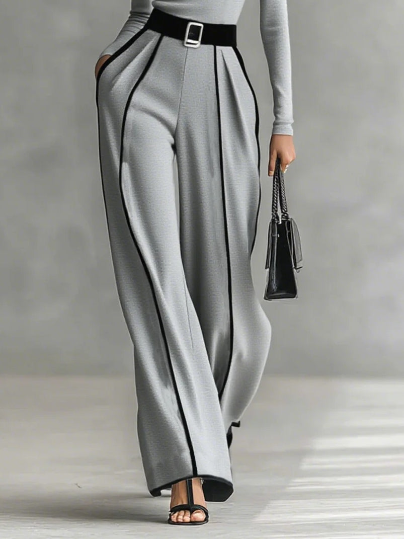 Conjunto gris con pantalón ancho y cinturón negro; costuras a contraste en la caída