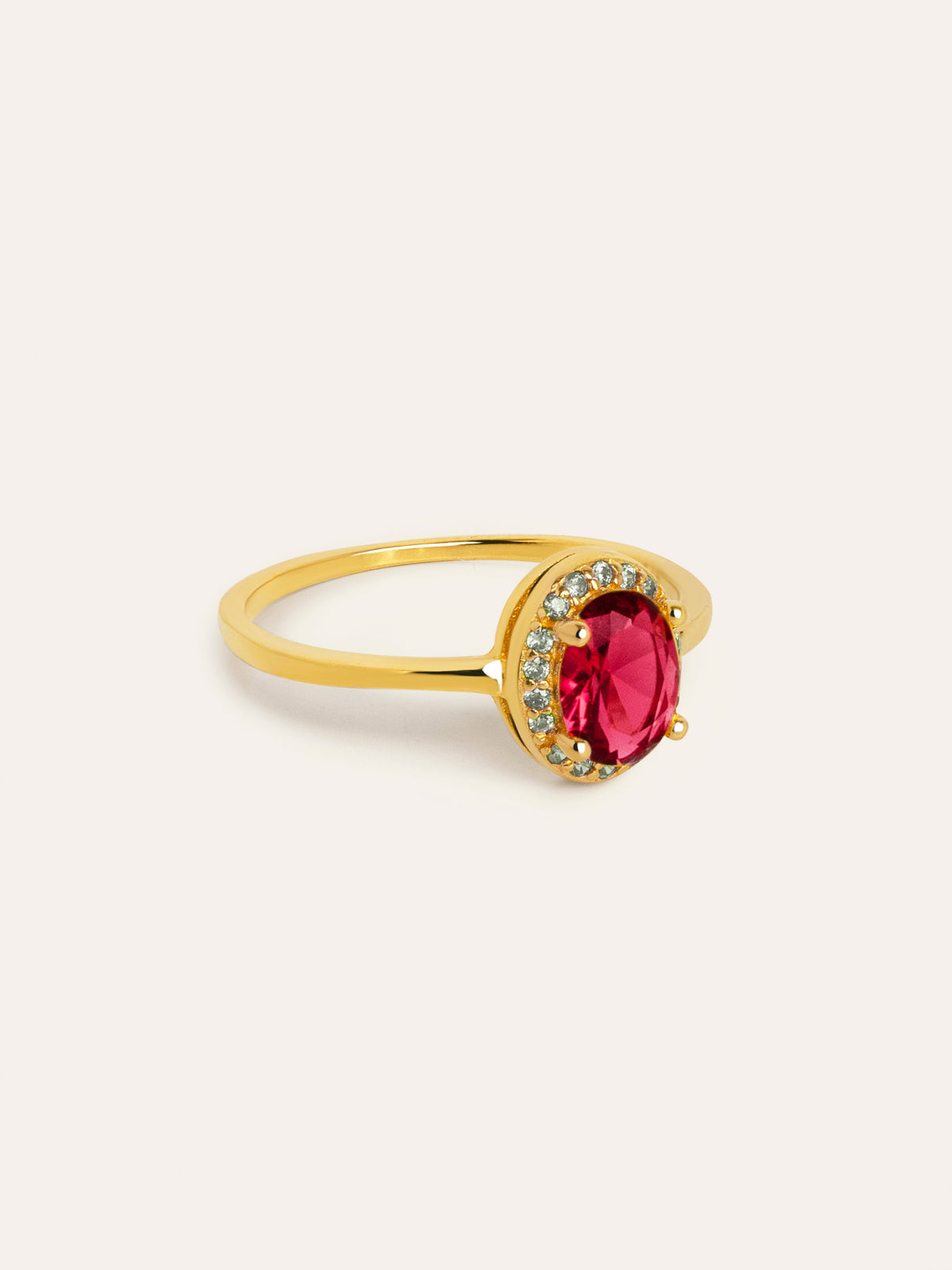 Anillo dorado con piedra ovalada roja y detalles brillantes alrededor