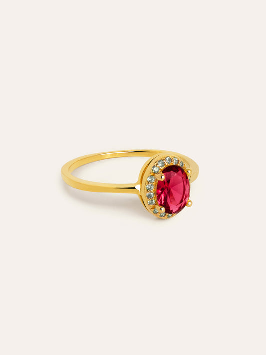 Anillo dorado con piedra ovalada roja y detalles brillantes alrededor