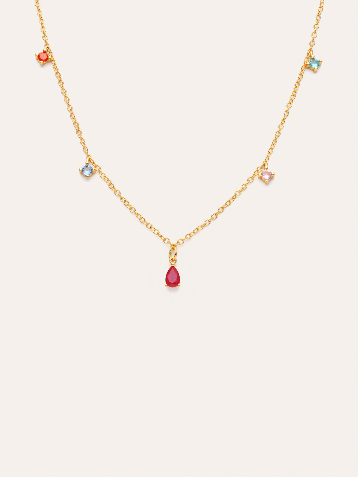 Collar dorado en cadena fina con dije rojo al centro y charms azules en los lados