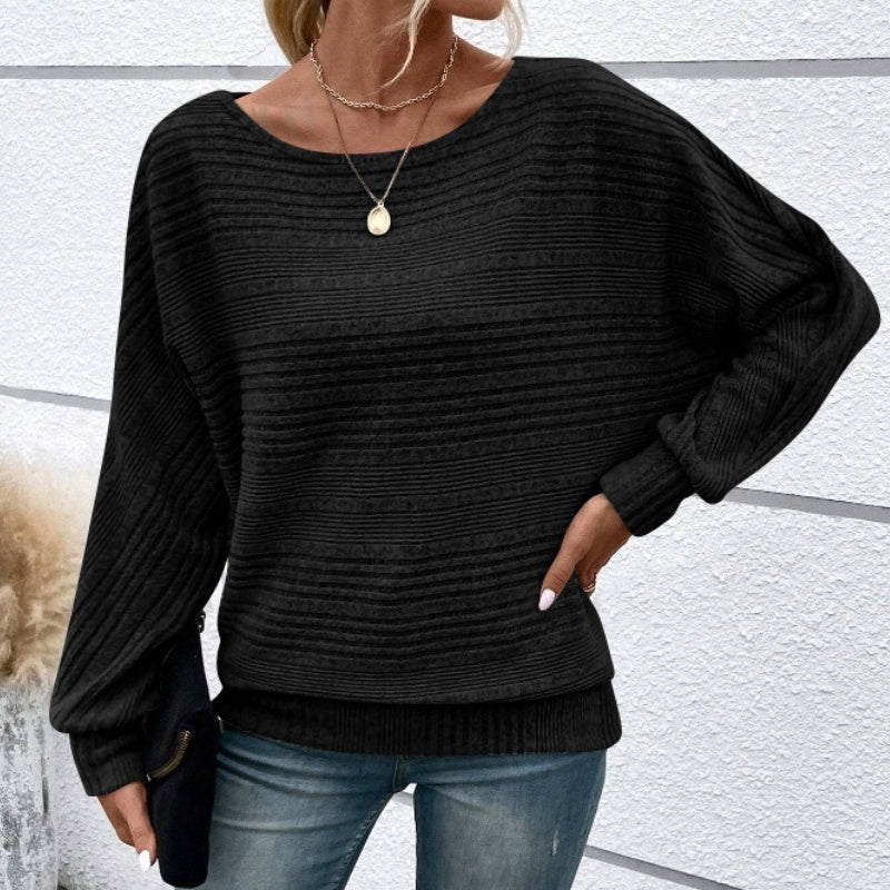 Jersey rayado negro de punto, cuello redondo y mangas largas abullonadas.