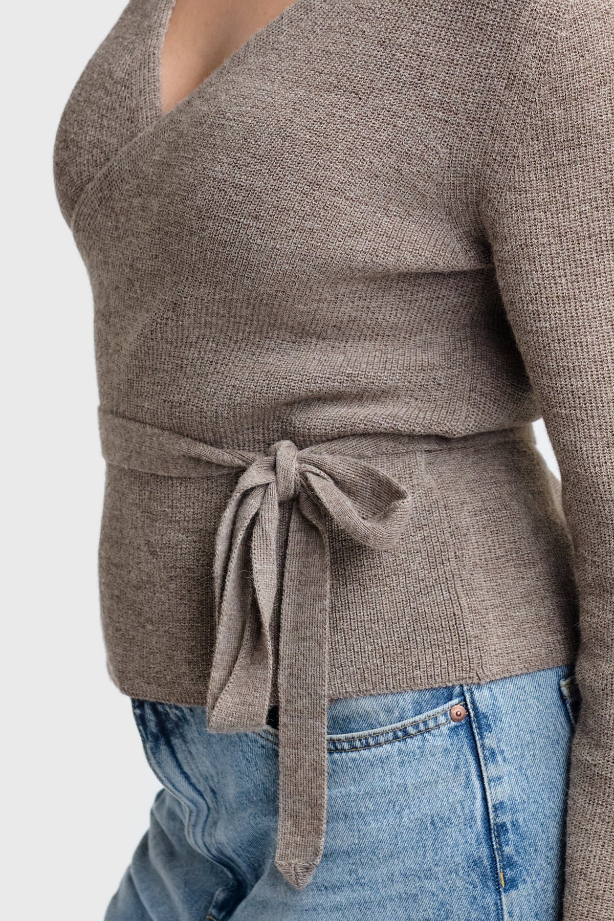 Jersey de punto gris cruzado, detalle de lazo ajustable en la cintura