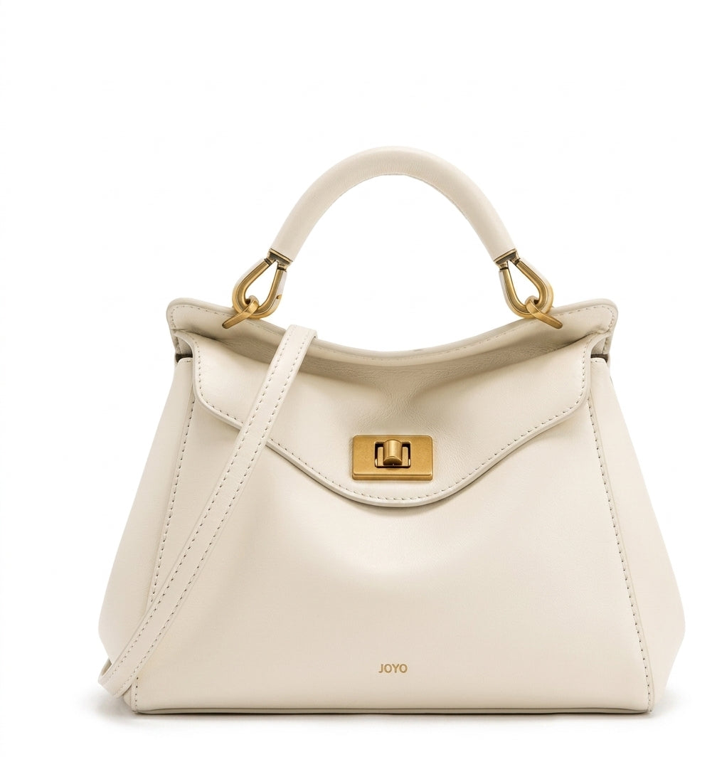 Bolso de piel lisa en tono crema con asa de arco y solapa frontal con cierre metálico.