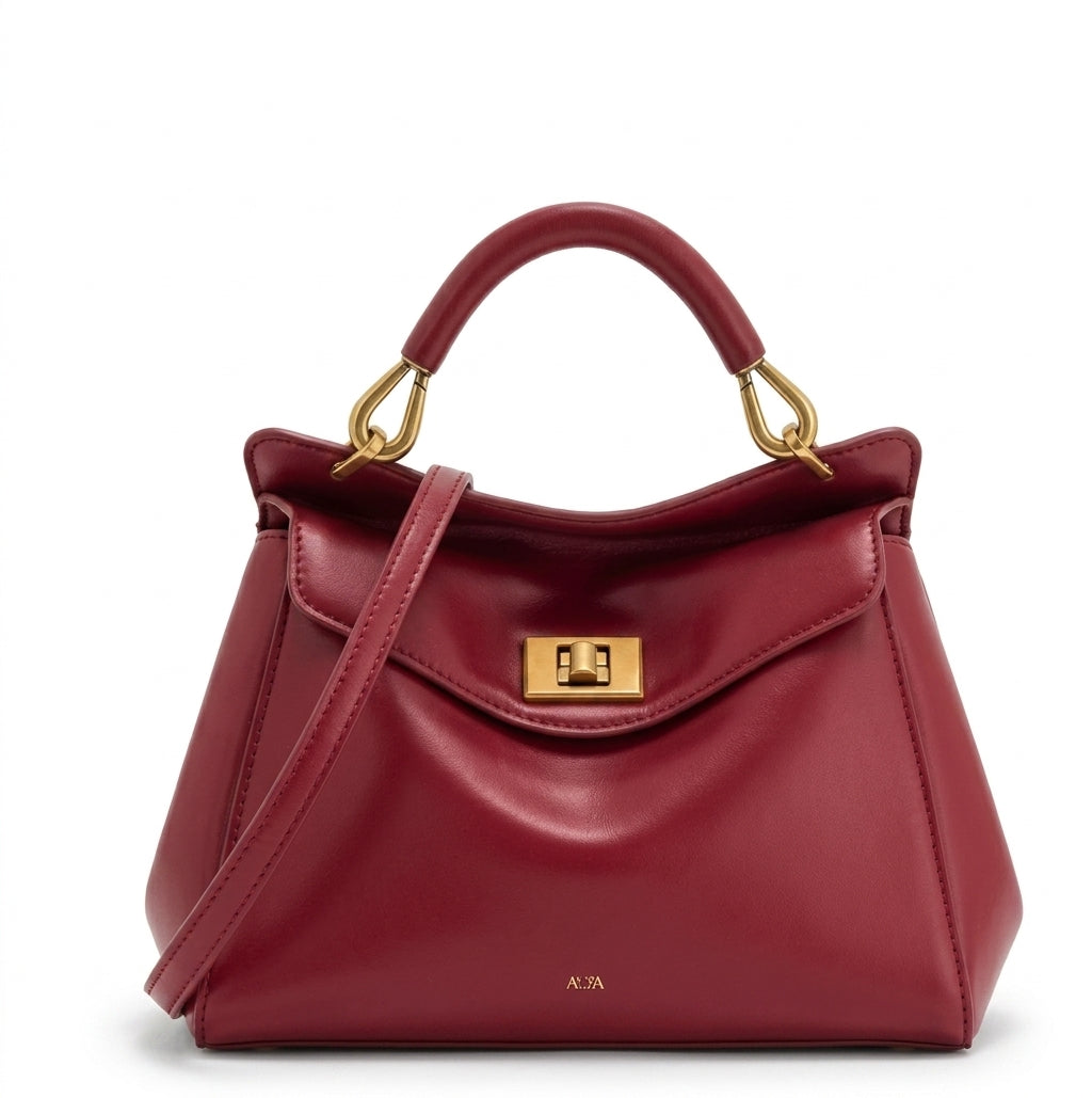 Bolso grande de piel lisa rojo con asa de arco, solapa frontal y cierre metálico dorado.