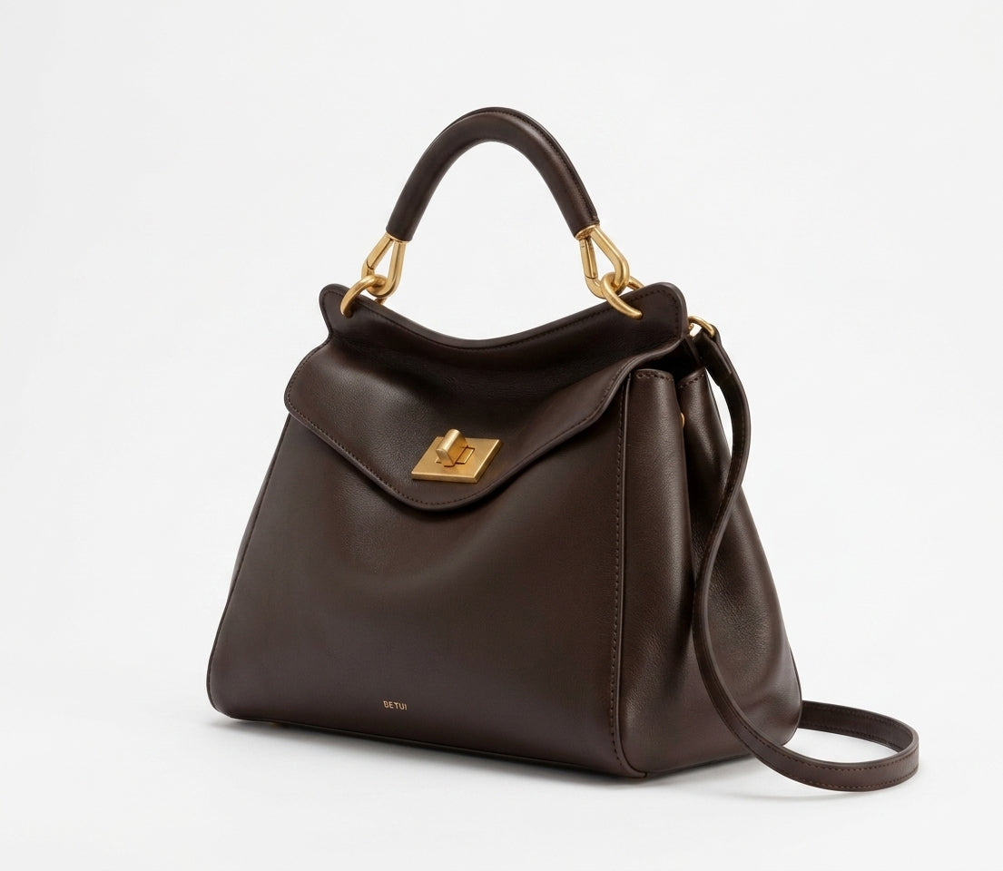 Bolso grande de mujer de piel lisa marrón, con asa superior y bandolera, solapa y herrajes dorados