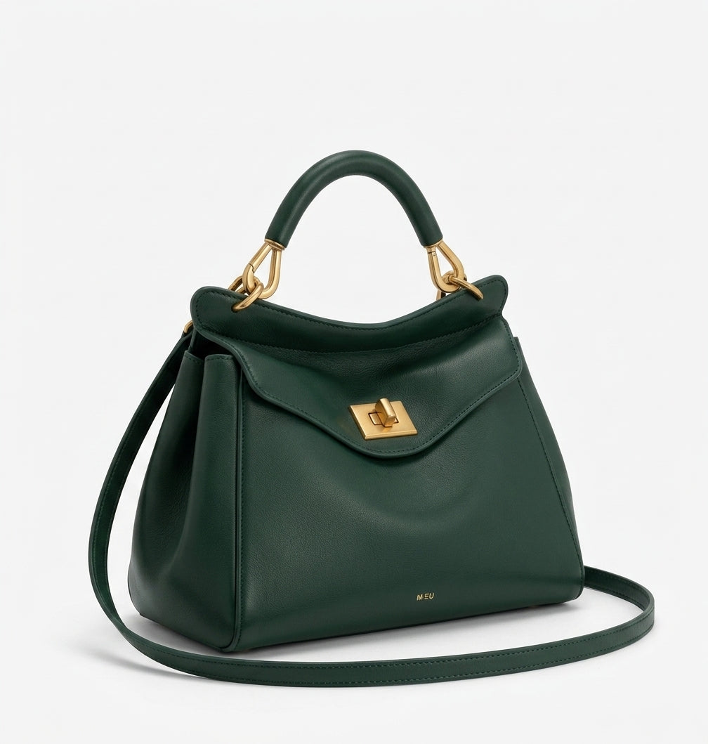 Bolso de piel lisa verde oscuro con asa de arco y bandolera, solapa frontal con cierre metálico.