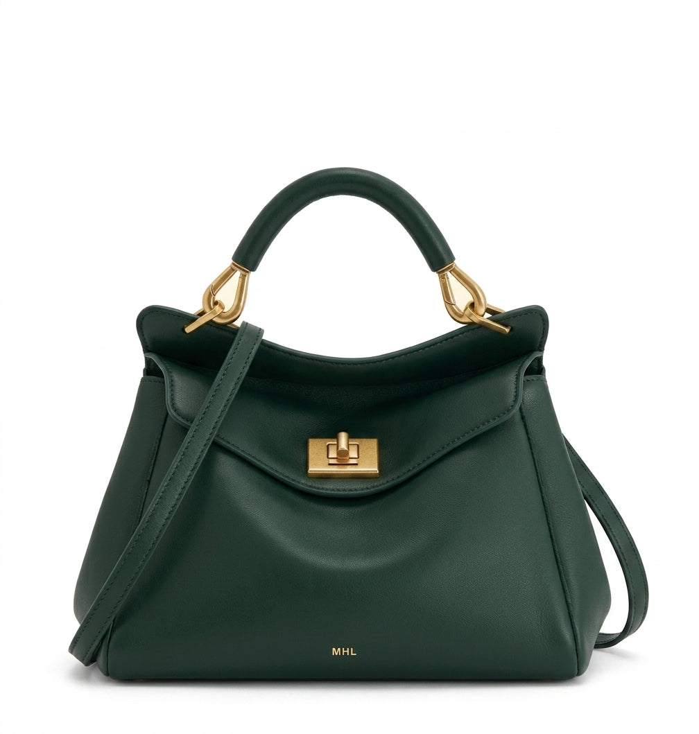 Bolso de piel lisa verde con asa de arco y bandolera, solapa frontal con cierre metálico.