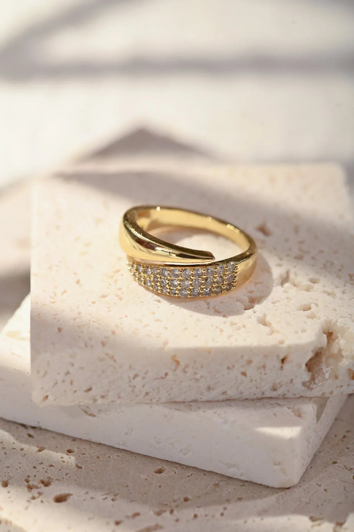 Anillo de oro con banda de piedras brillantes, sobre base blanca