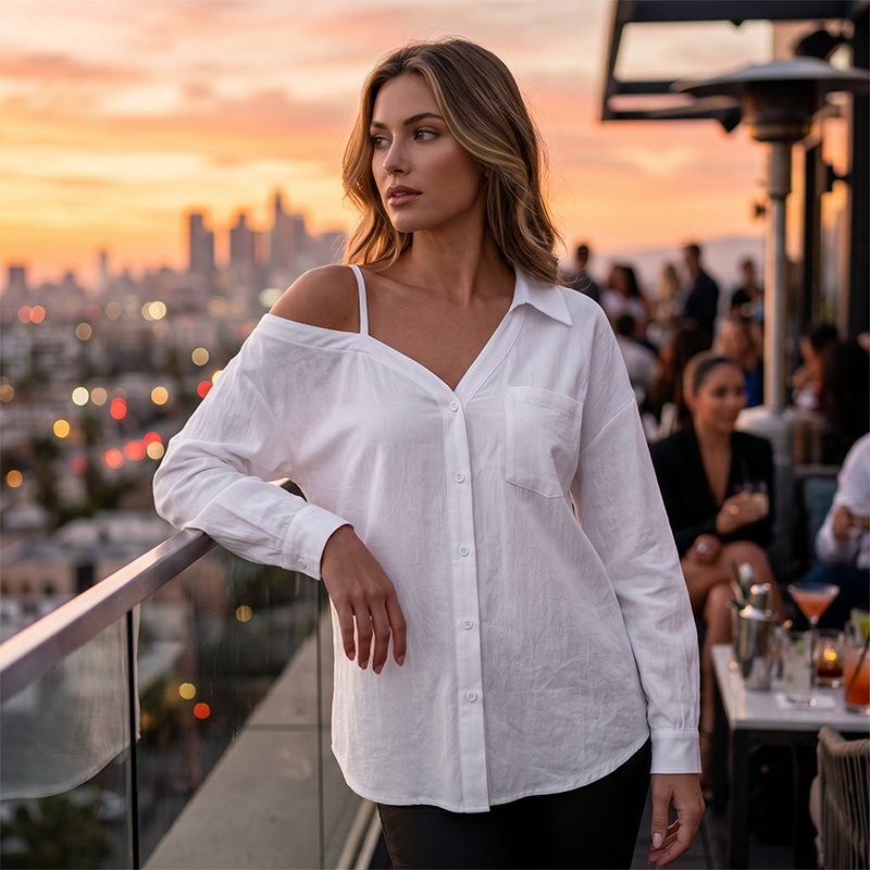 Camisa informal blanca con hombros descubiertos, botones al frente y bolsillos.